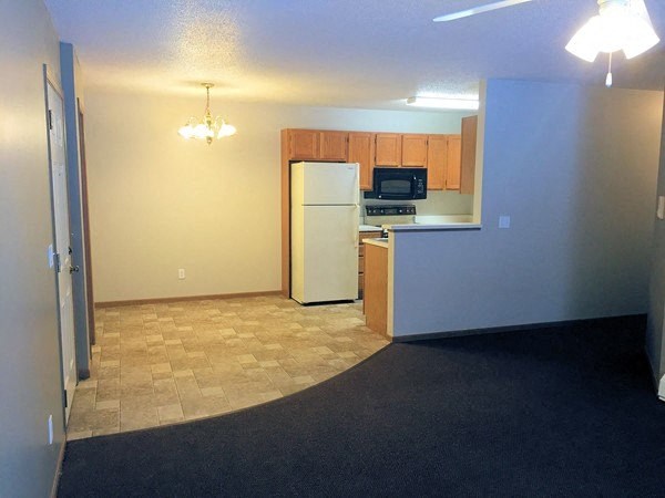 an empty kitchen with a refrigerator and a sink