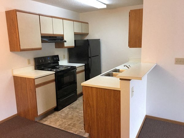 a kitchen with a stove and a black refrigerator