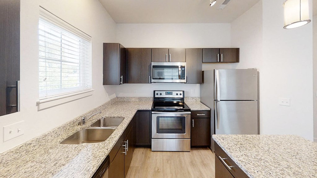 a kitchen with granite counter tops and stainless steel appliances