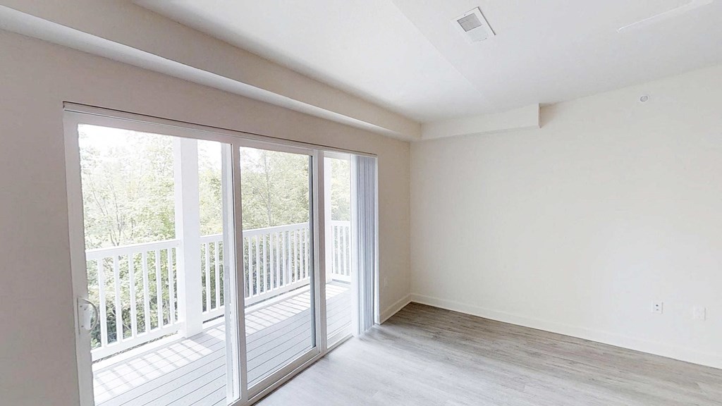 an empty living room with sliding glass doors to a balcony