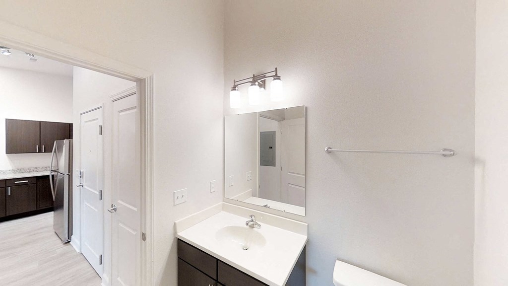 a white bathroom with a large mirror and a sink