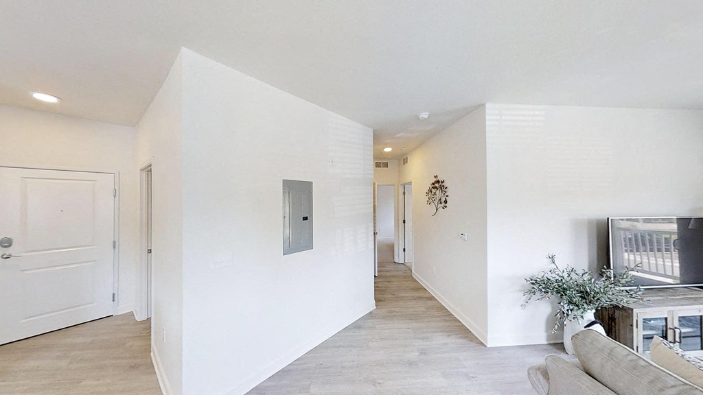 the living room and hallway of a home with white walls