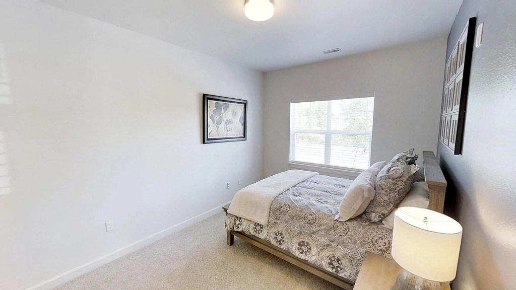 a bedroom with a bed and a window