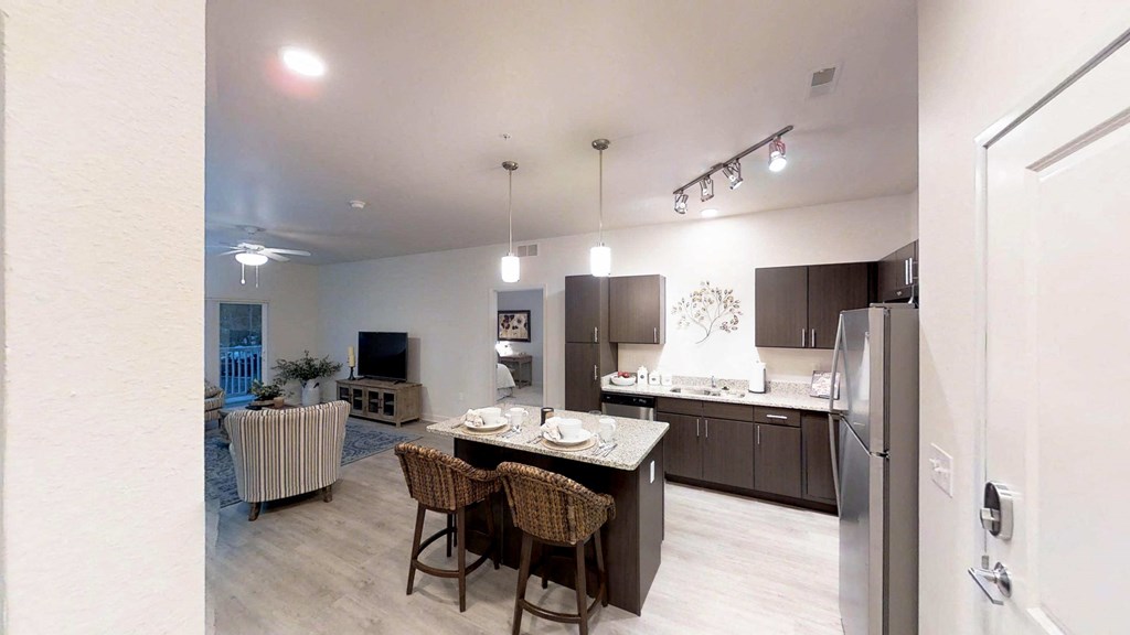 a kitchen and living room with a table and chairs