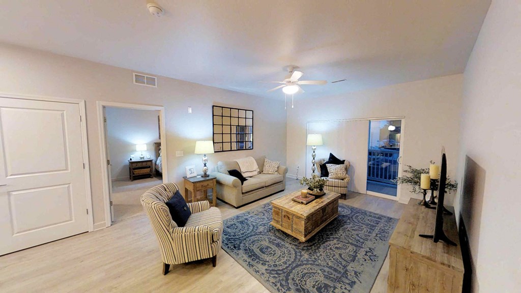 a living room with couches and chairs and a rug