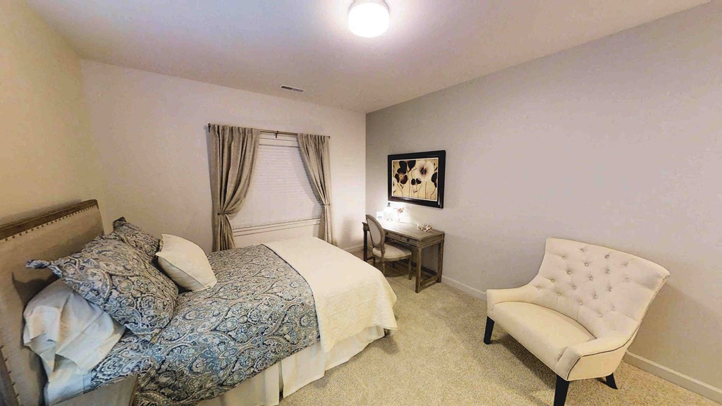 a bedroom with a bed and a chair