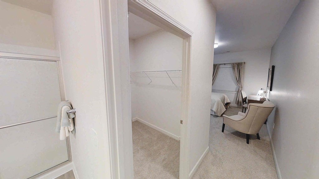 a bedroom with a closet and a closet door open to a room with a bed