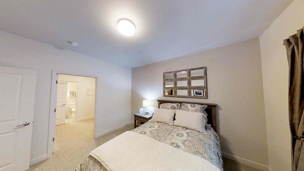 a bedroom with a bed and a door to a bathroom