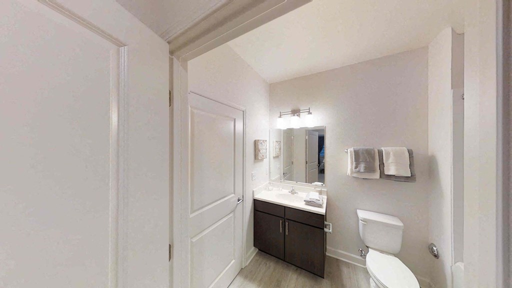 a bathroom with a sink toilet and a mirror