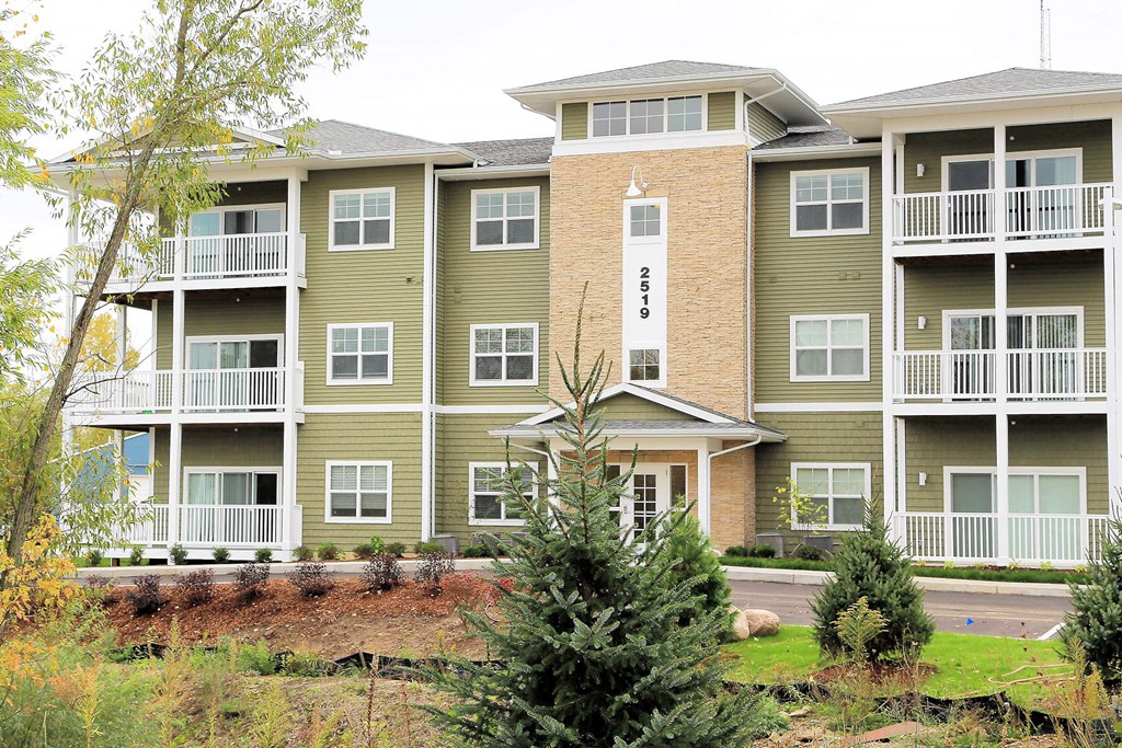 an apartment building with trees in front of it