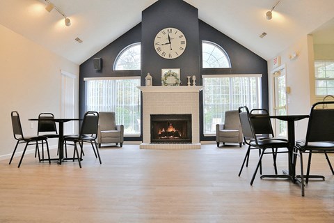 a living room with a fireplace and a clock on the wall