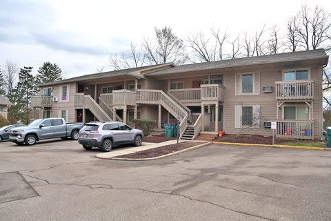 A two-story apartment building with a parking lot in front.