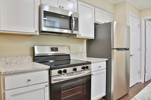 A kitchen with white cabinets and stainless steel appliances.