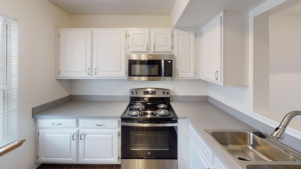A kitchen with white cabinets and stainless steel appliances.