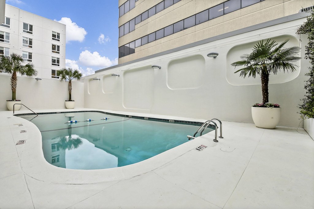 A pool with a white building in the background at The Palms on Main, Columbia