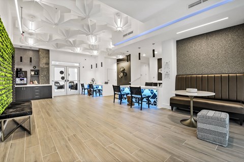 A modern dining area with a green wall and wooden floors.