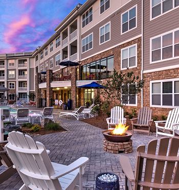 A patio with chairs and a fire pit in front of a building at Residence at Tailrace Marina, Mount Holly, NC