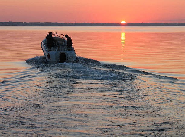 a boat in the water on Lake Murray with a sunset in the background at The Residence at Marina Bay, Irmo, South Carolina