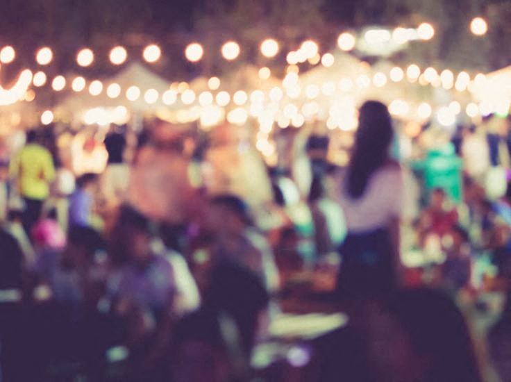 a blurry image of a crowd of people at a festival