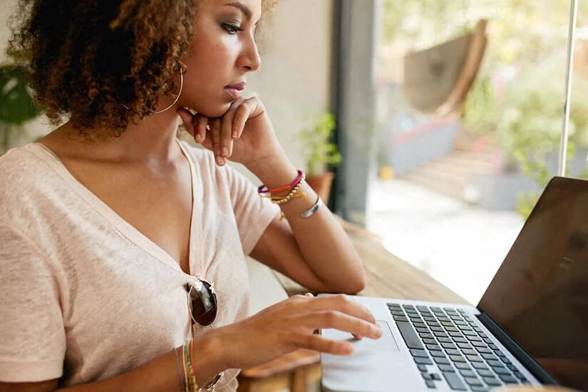 a woman sitting at a table using a laptop computer