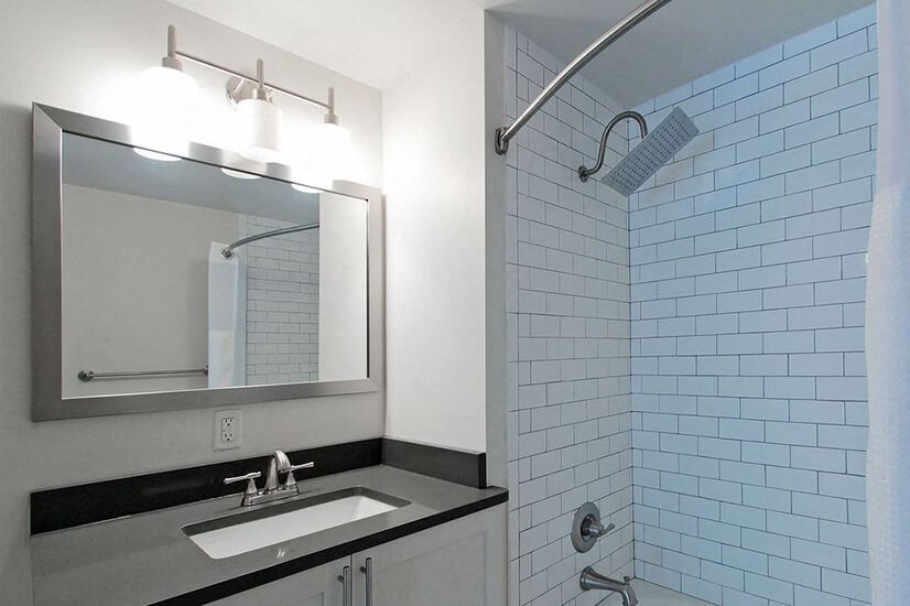 a bathroom with a sink and a mirror and a shower