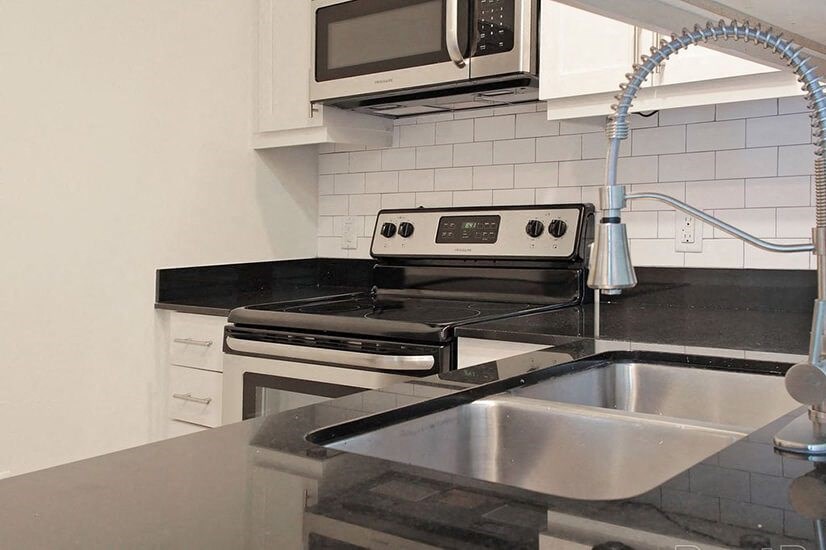 a kitchen with a stove and sink and a microwave