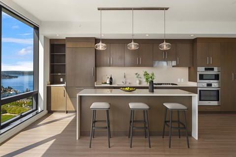 A modern kitchen with a large island and bar stools.