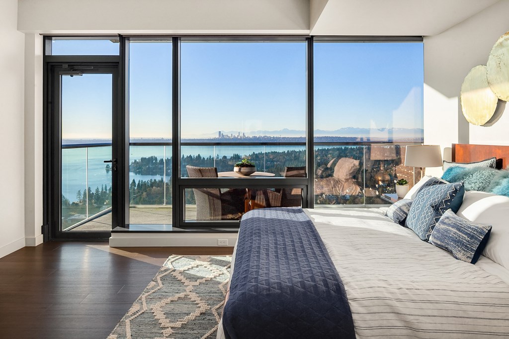 a bedroom with a bed and a view of the water and mountains at Two Lincoln Tower, Bellevue, WA, 98004
