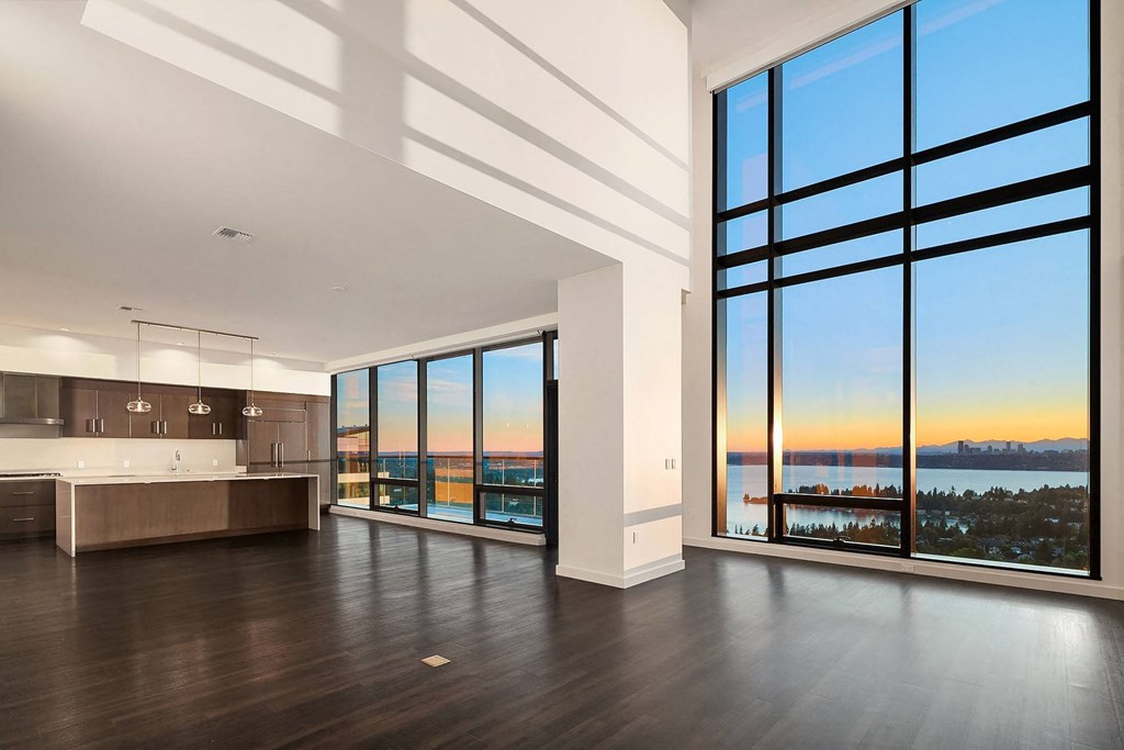 an open living room with a view of the water and sunset at Two Lincoln Tower, Bellevue, WA, 98004