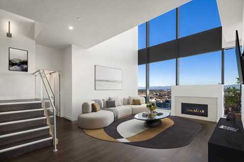 A modern living room with a staircase and a fireplace.