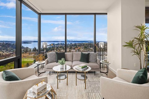 a living room with a couch and a view of a city and the ocean