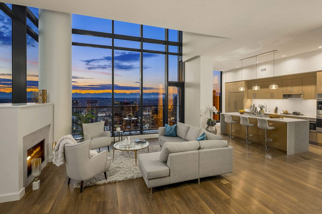 an open living room with couches and a table and a kitchen with a fireplace at Two Lincoln Tower, Bellevue, WA