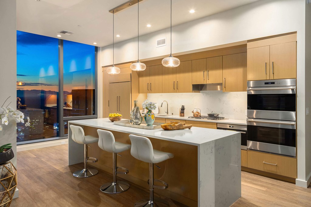 the kitchen has a large island with white quartz countertops and stainless steel appliances at Two Lincoln Tower, Bellevue, WA, 98004