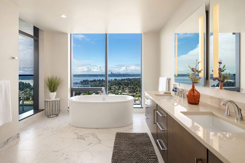 A modern bathroom with a large window overlooking a cityscape.