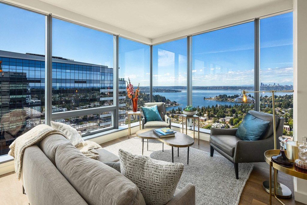 a living room with a couch and chairs and a view of the city and water at Two Lincoln Tower, Bellevue, WA