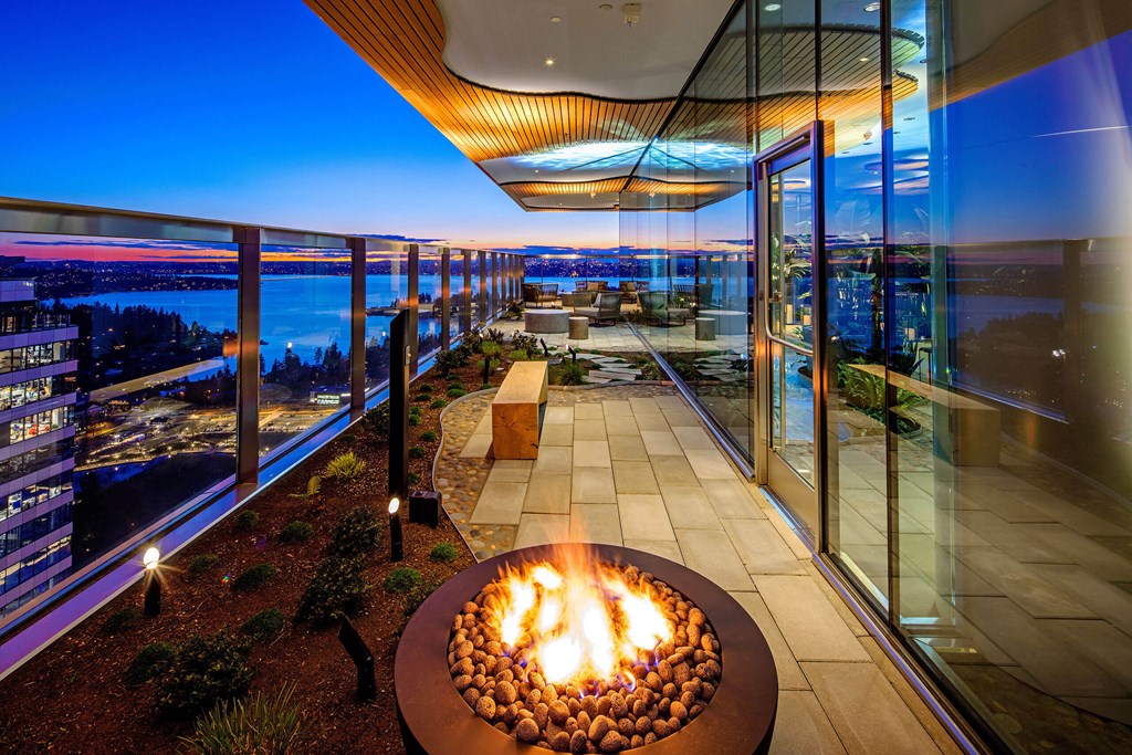 a fire pit on a balcony overlooking a city at night at Two Lincoln Tower, Bellevue, WA