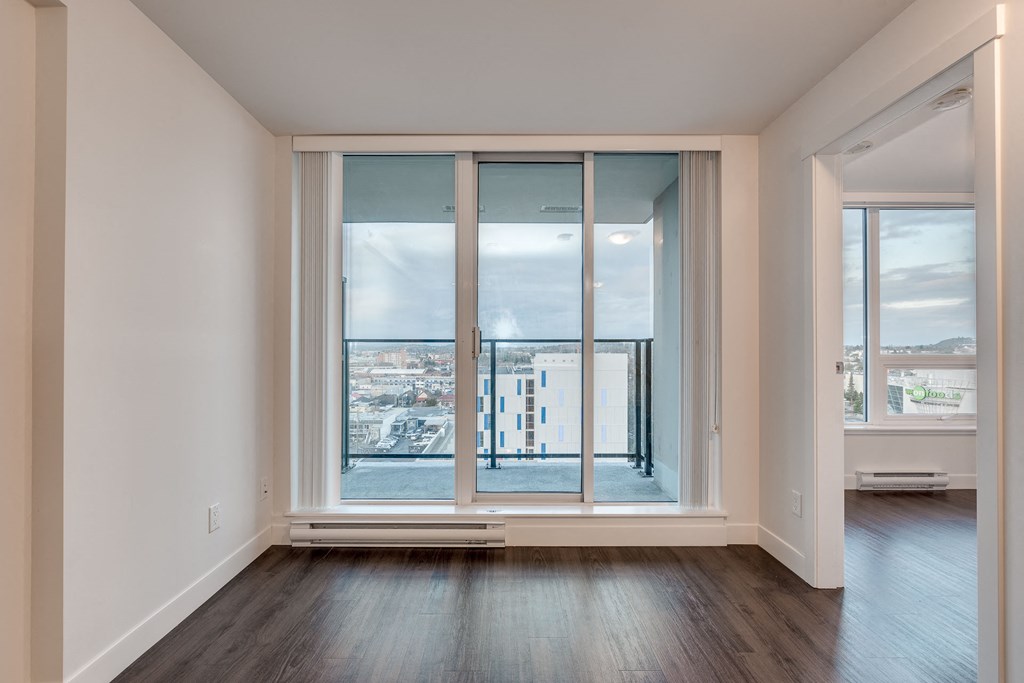 a bedroom with hardwood floors and white walls