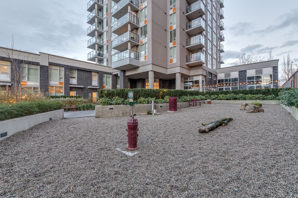 a courtyard with a fire hydrant and benches in front of an apartment building