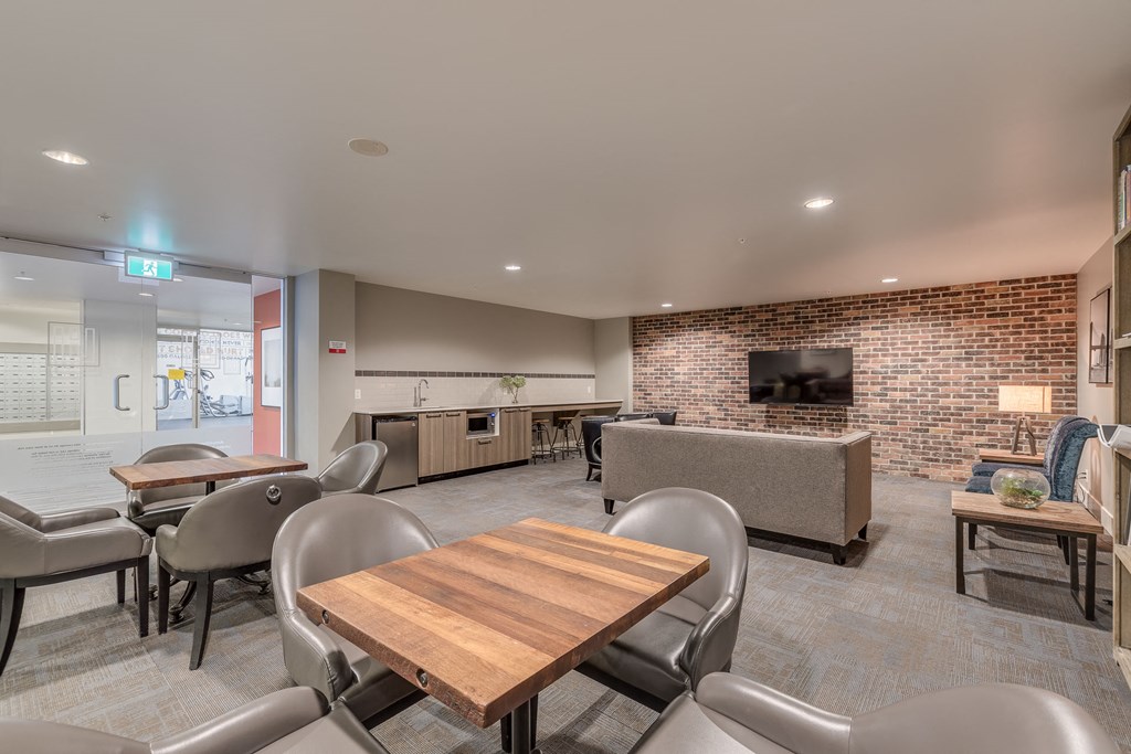 a lounge area with tables chairs and a television