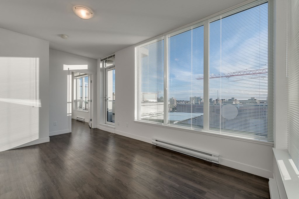 a bedroom with a large window and hardwood floors