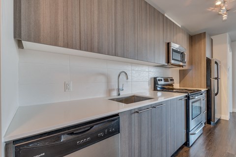 a kitchen with white countertops and wooden cabinets