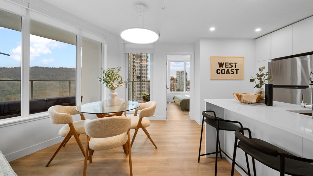 A modern kitchen with a dining table and chairs.