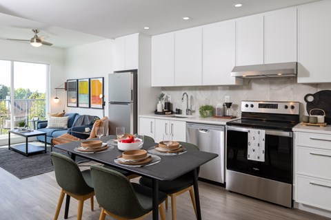 A modern kitchen with a dining table set for two.