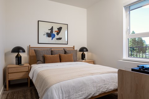 A bedroom with a large bed and a painting above it.