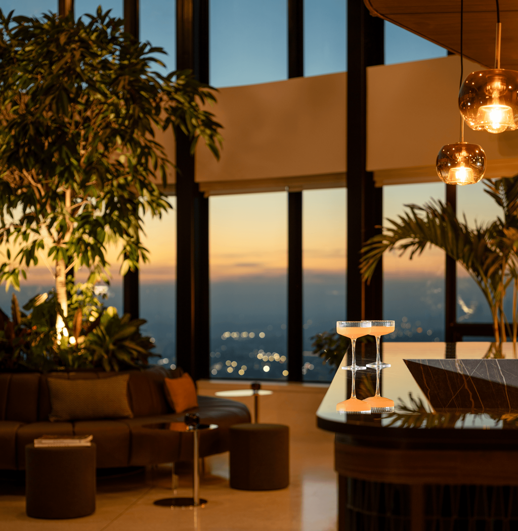 A modern living room with a view of the city at dusk.