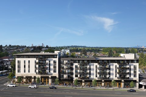 Two modern apartment buildings are situated on a street corner with cars parked in front.