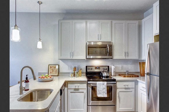 a kitchen with stainless steel appliances and white cabinets