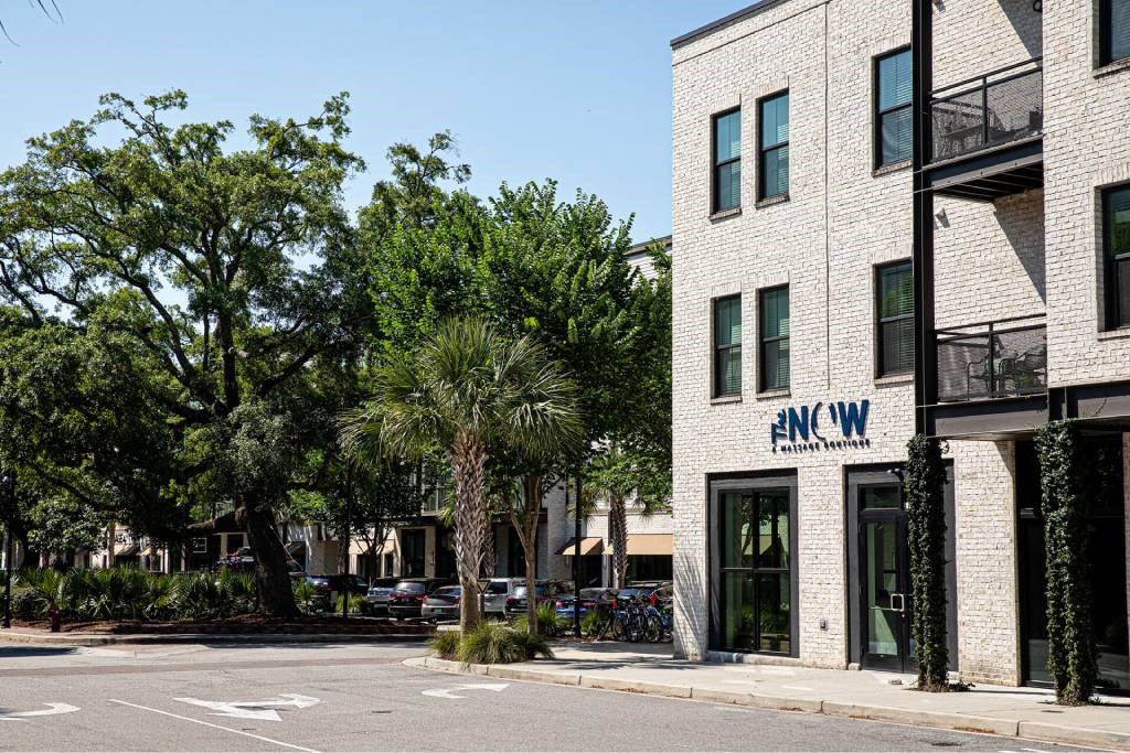 A building with the letters FNW on it is surrounded by trees.