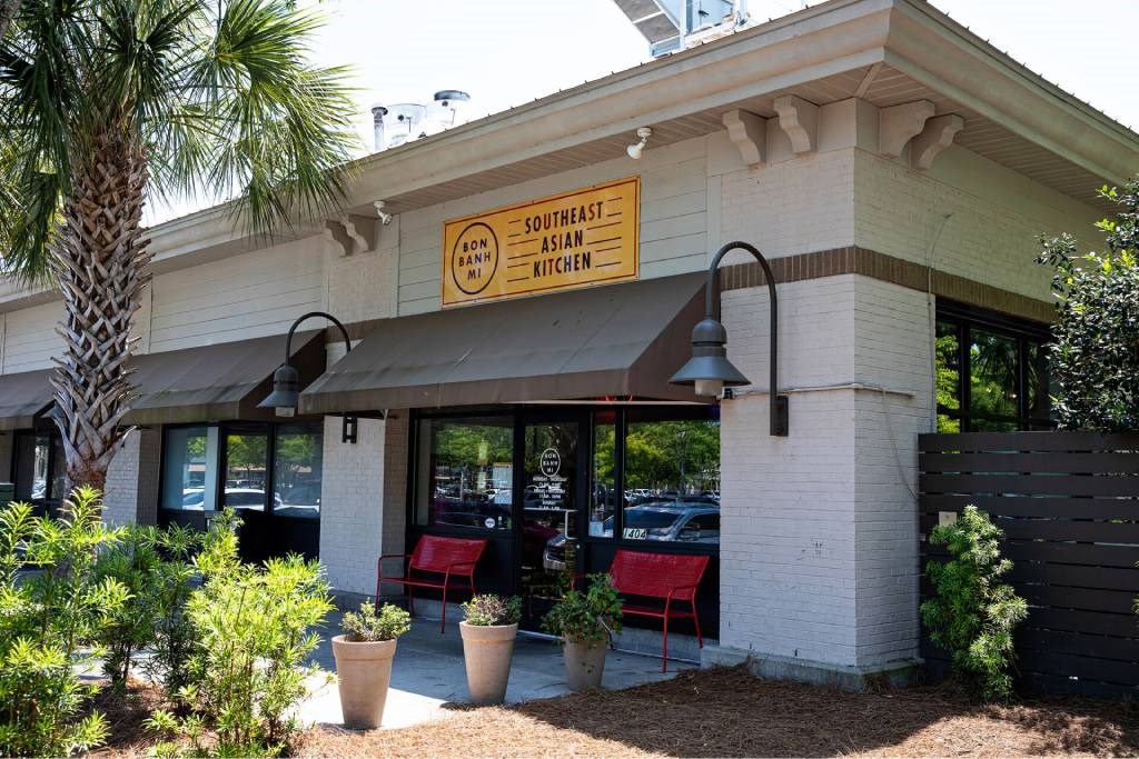 A restaurant named Southeast Asian Kitchen has a red chair outside.