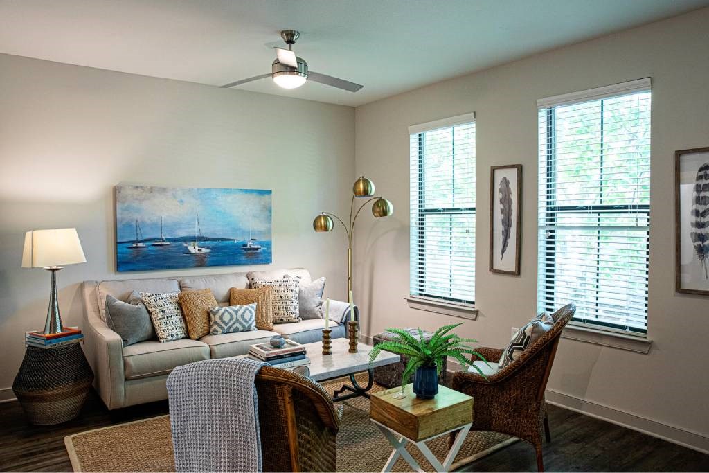 A living room with a couch, a chair, a table, and a painting on the wall.